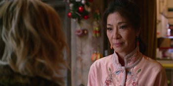 An older woman wearing a pink shirt looking at a younger woman