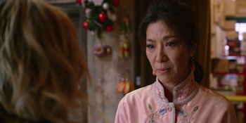 Movie still from “Last Christmas” (2019), directed by Paul Feig – An older woman wearing a pink jacket looking sad; Close Up shot, Over the shoulder angle