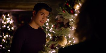 Movie still from “Last Christmas” (2019), directed by Paul Feig – A man standing in front of a christmas tree; Close Up shot, Over the shoulder angle