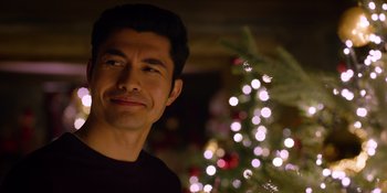 Movie still from “Last Christmas” (2019), directed by Paul Feig – A man standing in front of a christmas tree; Close Up shot, Over the shoulder angle