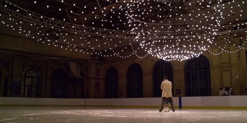 Movie still from “Last Christmas” (2019), directed by Paul Feig – Two people on ice skates on an ice rink; Extreme Wide shot, Low angle
