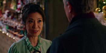 Movie still from “Last Christmas” (2019), directed by Paul Feig – An older woman in a green blouse and a man in a black suit; Close Up shot, Over the shoulder angle