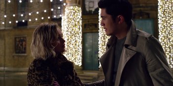 Movie still from “Last Christmas” (2019), directed by Paul Feig – A man and a woman standing next to each other in front of lights; Close Up shot, Over the shoulder angle