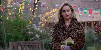 Movie still from “Last Christmas” (2019), directed by Paul Feig – A woman in a leopard print coat holding a drink; Medium shot, Over the shoulder angle