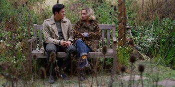 Movie still from “Last Christmas” (2019), directed by Paul Feig – A man and a woman sitting on a wooden bench; Medium shot, Over the shoulder angle