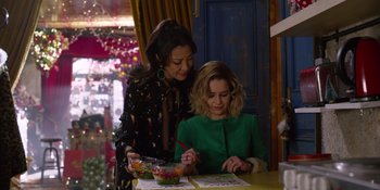 Movie still from “Last Christmas” (2019), directed by Paul Feig – Two women sitting at a table with a bowl of fruit; Medium shot, Over the shoulder angle