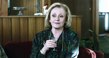 Movie still from “Last Night” (1998), directed by Don McKellar – A woman holding a wine glass in her hand; Close Up shot, Over the shoulder angle