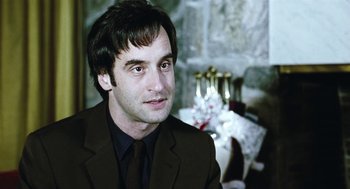 Movie still from “Last Night” (1998), directed by Don McKellar – A person wearing a suit and tie; Close Up shot, Over the shoulder angle