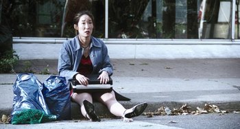 Movie still from “Last Night” (1998), directed by Don McKellar – A woman sitting on the ground with a laptop in her lap; Wide shot, High angle