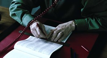 Movie still from “Last Night” (1998), directed by Don McKellar – A person writing on a piece of paper with a pen; Extreme Close Up shot, High angle