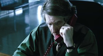 Movie still from “Last Night” (1998), directed by Don McKellar – A man is talking on a phone while sitting down; Close Up shot, Low angle