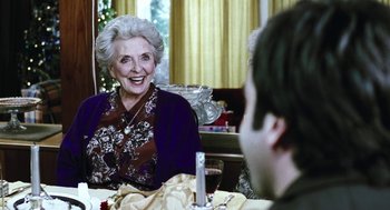 Movie still from “Last Night” (1998), directed by Don McKellar – An older woman sitting at a dinner table with a young man; Close Up shot, Over the shoulder angle