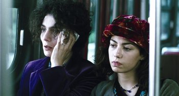 Movie still from “Last Night” (1998), directed by Don McKellar – Two women sitting next to each other and one on a cell phone; Close Up shot, High angle
