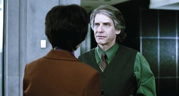 Movie still from “Last Night” (1998), directed by Don McKellar – A man in a green shirt and a woman in a brown tie; Close Up shot, Over the shoulder angle