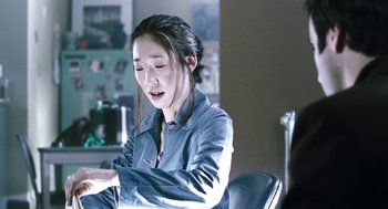 Movie still from “Last Night” (1998), directed by Don McKellar – A woman sitting at a table with a laptop; Close Up shot, Over the shoulder angle