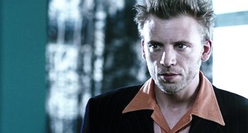 Movie still from “Last Night” (1998), directed by Don McKellar – A person wearing a suit and tie; Close Up shot, Low angle