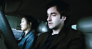 Movie still from “Last Night” (1998), directed by Don McKellar – A man and a woman sitting in the back of a car; Close Up shot, Low angle