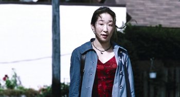 Movie still from “Last Night” (1998), directed by Don McKellar – A woman in a red dress and a blue jacket; Medium shot, High angle