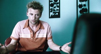 Movie still from “Last Night” (1998), directed by Don McKellar – A man with spiky spiky hair points to the side; Close Up shot, Low angle