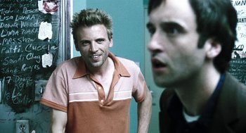 Movie still from “Last Night” (1998), directed by Don McKellar – A man in a brown and white shirt looking at a man in a black shirt; Close Up shot, Over the shoulder angle