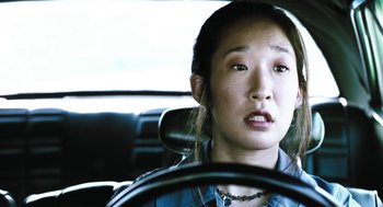 Movie still from “Last Night” (1998), directed by Don McKellar – A woman sitting in the driver's seat of a car; Close Up shot, High angle