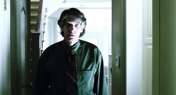 Movie still from “Last Night” (1998), directed by Don McKellar – A man wearing a green shirt and a red tie; Medium shot, Low angle