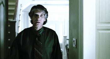 Movie still from “Last Night” (1998), directed by Don McKellar – A man wearing a green shirt and a red tie; Medium shot, Low angle