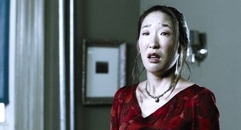 Movie still from “Last Night” (1998), directed by Don McKellar – A woman in a red dress is looking at the camera; Close Up shot, Low angle