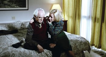 Movie still from “Last Night” (1998), directed by Don McKellar – An older man sitting on a bed with a woman; Medium shot, Low angle