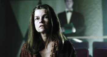 Movie still from “Last Night” (1998), directed by Don McKellar – A woman with long brown hair looking at the camera; Close Up shot, Low angle