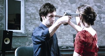 Movie still from “Last Night” (1998), directed by Don McKellar – A man holding a gun up to a woman's face; Close Up shot, Over the shoulder angle