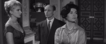 Movie still from “Last Year at Marienbad” (1961), directed by Alain Resnais – A man and a woman standing next to each other; Medium shot, Low angle