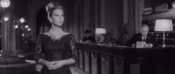 Movie still from “Last Year at Marienbad” (1961), directed by Alain Resnais – A black and white photo of a woman in a black dress; Medium shot, Low angle