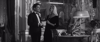 Movie still from “Last Year at Marienbad” (1961), directed by Alain Resnais – A man and a woman standing next to each other; Medium shot, Low angle