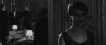 Movie still from “Last Year at Marienbad” (1961), directed by Alain Resnais – A black and white photo of a woman in a dress; Close Up shot, Over the shoulder angle