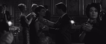 Movie still from “Last Year at Marienbad” (1961), directed by Alain Resnais – A man and a woman in formal wear dancing together; Medium shot, Low angle