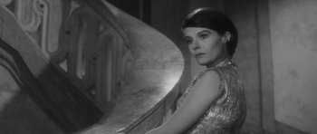 Movie still from “Last Year at Marienbad” (1961), directed by Alain Resnais – Black and white photograph of a woman in a dress; Close Up shot, High angle