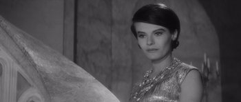 Movie still from “Last Year at Marienbad” (1961), directed by Alain Resnais – A black - and - white photo of a woman in a dress; Close Up shot, Over the shoulder angle