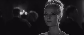 Movie still from “Last Year at Marienbad” (1961), directed by Alain Resnais – A black - and - white photo of a woman with a necklace; Close Up shot, Low angle