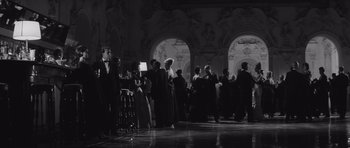 Movie still from “Last Year at Marienbad” (1961), directed by Alain Resnais – A black and white photo of people in formal wear; Wide shot, Low angle