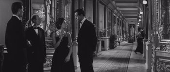 Movie still from “Last Year at Marienbad” (1961), directed by Alain Resnais – A man and a woman standing next to each other; Medium shot, Low angle