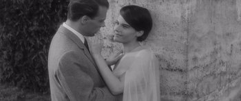 Movie still from “Last Year at Marienbad” (1961), directed by Alain Resnais – A black and white photo of a man and a woman; Close Up shot, Over the shoulder angle