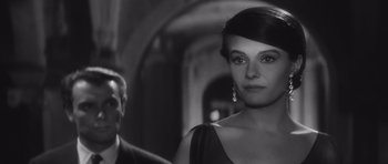 Movie still from “Last Year at Marienbad” (1961), directed by Alain Resnais – A black - and - white photo of a woman and a man; Close Up shot, Over the shoulder angle