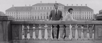 Movie still from “Last Year at Marienbad” (1961), directed by Alain Resnais – A man and a woman standing on a balcony; Medium shot, Low angle