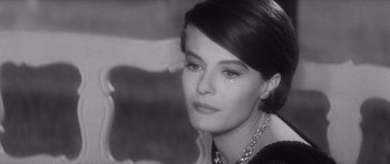 Movie still from “Last Year at Marienbad” (1961), directed by Alain Resnais – Black and white photograph of a woman with a necklace; Close Up shot, Over the shoulder angle