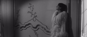 Movie still from “Last Year at Marienbad” (1961), directed by Alain Resnais – A black and white photo of a woman in a fur coat; Medium shot, Overhead angle