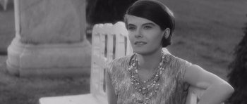 Movie still from “Last Year at Marienbad” (1961), directed by Alain Resnais – Black and white photograph of a woman wearing a necklace; Close Up shot, Over the shoulder angle