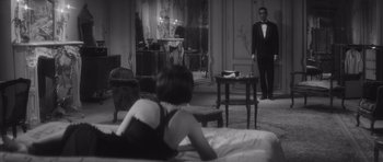 Movie still from “Last Year at Marienbad” (1961), directed by Alain Resnais – A man and a woman are in a room; Medium shot, Over the shoulder angle