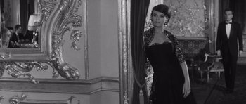 Movie still from “Last Year at Marienbad” (1961), directed by Alain Resnais – A woman standing in front of a mirror in front of a curtain; Medium shot, Low angle