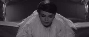 Movie still from “Last Year at Marienbad” (1961), directed by Alain Resnais – A black - and - white photo of a woman in a white dress; Close Up shot, High angle